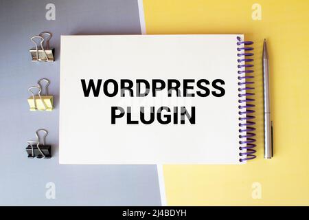 Business concept.Text Wordpress Plugin writing on notepaper with pencil,paper clips and glasses on yellow background. Stock Photo