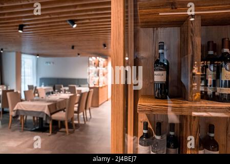 Various liquor bottles in glass display against dining room at luxurious hotel Stock Photo