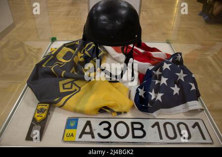 Trophies captured by the Russian military in Ukraine in 2022 are on display at the State Central Museum of Contemporary History of Russia in Moscow. The sign reads: “Protective helmet of a soldier of the Armed Forces of Ukraine with an emblem indicating affiliation to the SS. Ukraine, 2022. The flag of the Azov special operations detachment that adheres to far-right and neo-Nazi ideology and uses weapons provided by NATO. Ukraine, 2022. U.S. flag with traces of shelling. Ukraine, 2022. A patch and badge of a soldier of the Azov special operations detachment that adheres to far-right and neo-Na Stock Photo