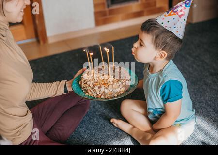 Boy celebrating his first birthday with cake, candles, balloons at home. Birthday party. Celebrate party. Happy birthday. Holiday, birthday. Stock Photo