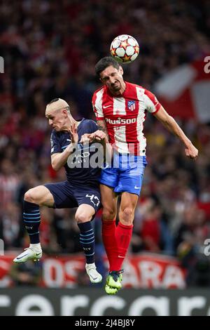 Madrid, Spain. 13th Apr, 2022. Stefan Savic (R) of Atletico de Madrid vies with Phil Foden of Manchester City during a UEFA Champions League quarterfinal second leg match between Atletico de Madrid of Spain and Manchester City FC of England at Wanda Metropolitano Stadium in Madrid, Spain, April 13, 2022. Credit: Meng Dingbo/Xinhua/Alamy Live News