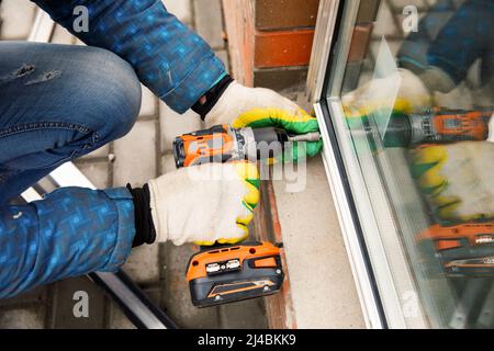 The wizard is engaged in installing windows. Repair work. Stock Photo