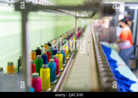 Multicolor sewing threads on industrial embroidery machine. select focus of Multicolor sewing threads. tailor sewing concept. Stock Photo