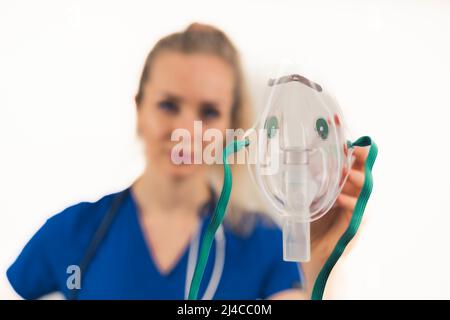 Studio Portrait Of Female Doctor Holding Oxygen Mask Over White Background. Focus On The Foreground. High quality photo Stock Photo