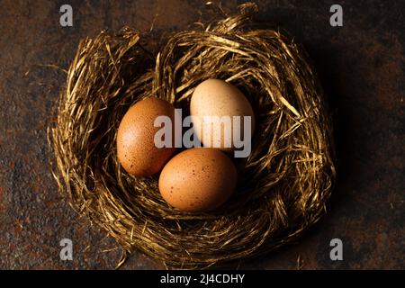 Big red eggs in a golden nest photo in rustic style Stock Photo