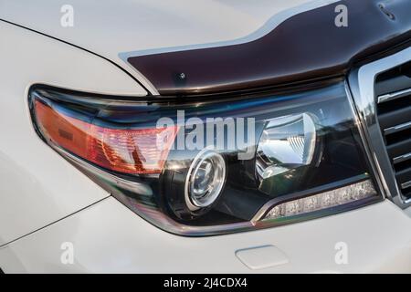 Novosibirsk, Russia - 04. 12. 2022: Front headlight view of Toyota Land Cruiser 200 j200 2013 year with led lamp white color after cleaning before sal Stock Photo