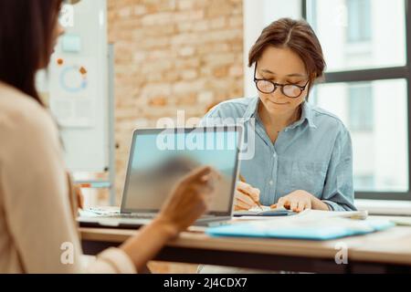 Two young women working together with new project Stock Photo