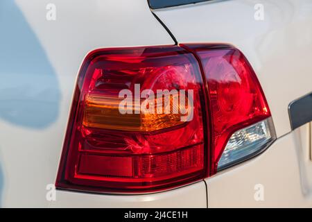Novosibirsk, Russia - 04. 12. 2022: Rear taillight view of Toyota Land Cruiser 200 j200 2013 year white color after cleaning before sale in a sunny da Stock Photo