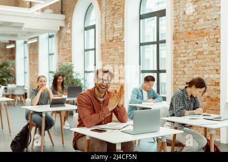 Happy young man working with laptop in classroom Stock Photo