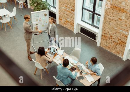 Two colleagues shaking hands during a meeting in the office Stock Photo