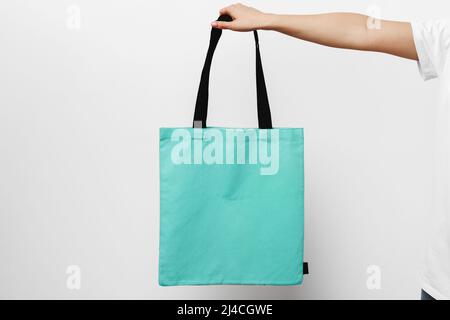 Female hand holding eco or reusable shopping bag against white background Stock Photo