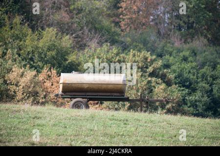 Domestic cattle (Bos taurus), mobile water trough in the form of a trailer stands on the pasture, Velbert, Germany Stock Photo