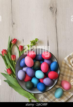 Decorative easter eggs in bowl on wooden table Stock Photo
