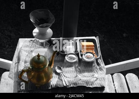 Coffee drip pot glass jar, Brass kettle jar, sugar sachet and biscuits Stock Photo