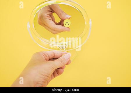 Conceptual image of happiness and wellness of a smiley face reflected in a mirror in yellow color Stock Photo