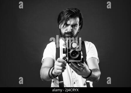 best photographer. handsome hipster making vintage photo. mature journalist use old technology. bearded camera man in suspenders. brutal guy Stock Photo