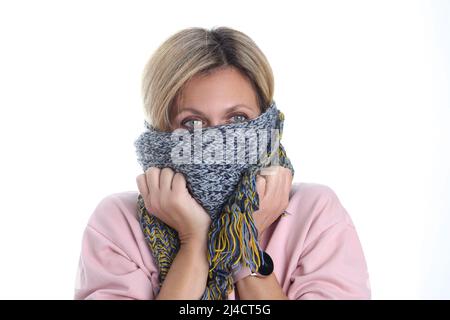 Woman wrapped in knitted scarf, suffering from flu, feels bad, catch cold, runny nose, sore throat Stock Photo