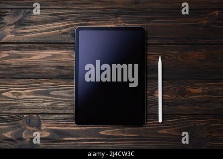 Tablet pcand stylus on a wooden background . Stock Photo