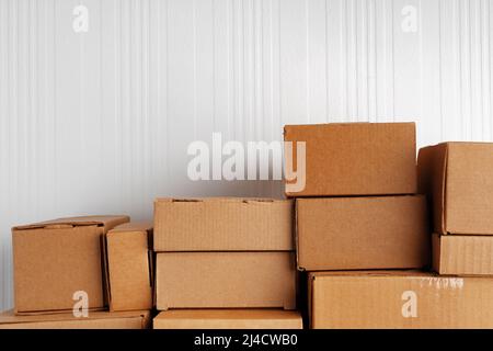 Group of cardboard boxes against white wooden wall Stock Photo
