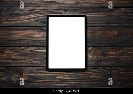tablet computer with a green screen on a wooden background. Stock Photo