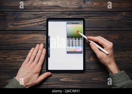 man works with a color palette on a graphic tablet. Stock Photo
