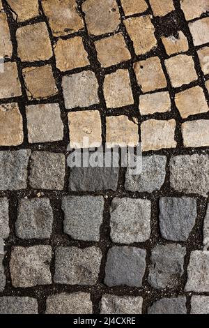 Mosaic of small marble cubes. sidewalks and squares formed by stone carpet with squares. Old cobblestones. High quality photo Stock Photo