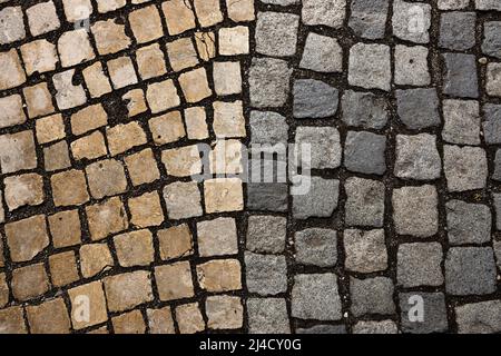Mosaic of small marble cubes. sidewalks and squares formed by stone carpet with squares. Old cobblestones. High quality photo Stock Photo