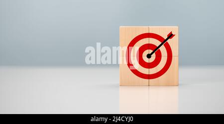 Business achievement goal and objective target concept. Initiation for planning to reach target. Darts target aim icon on wooden cubes with grey backg Stock Photo
