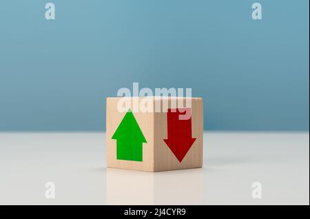 Rising and falling trends. green up arrow in bright side and red down arrow in dark side which print screen on wooden cube block for economic and busi Stock Photo