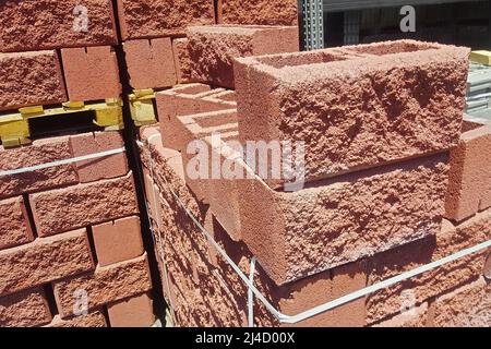 Hollow red spliter blocks bricks stacked on pallets for sale. Stock Photo