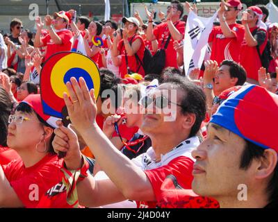 Football fans in the Berlin 'Fan Mile' zone in Brandenburg Park watching match (South Korea v Togo) on big screen during the 2006 FIFA World Cup in Germany. 13 June 2006, Berlin, Germany, Europe. Fan zones with large screens for public viewing of matches took place in 12 host cities across Germany attracting millions of visitors. Stock Photo