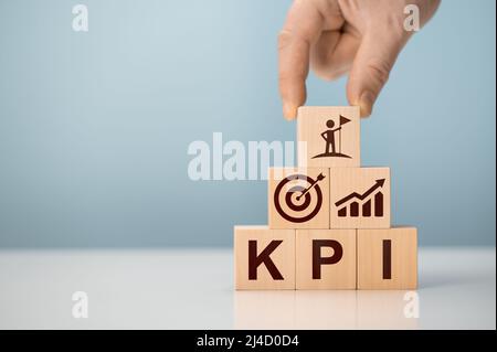 KPI - Key Performance Indicator. Businessman holds cube with KPI icon, KPI key performance indicator increase optimisation business. Business planning Stock Photo