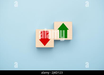 Rising and falling trends. green up arrow in bright side and red down arrow in dark side which print screen on wooden cube block for economic and busi Stock Photo