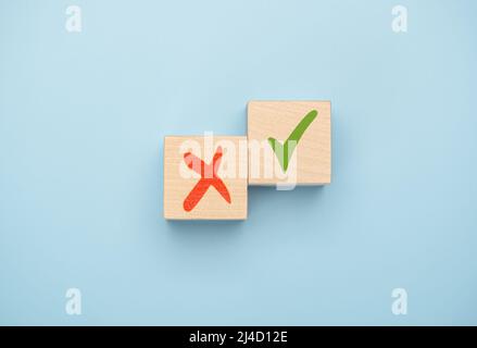 Tick mark and cross mark x on wooden cubes. Concept of positive or negative decision making or choice of approval or rejection. chooses checkmark and Stock Photo