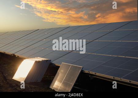 Solar pannels at full power on the farm. Solar photovoltaic power generation, sunset . Mounting Stock Photo