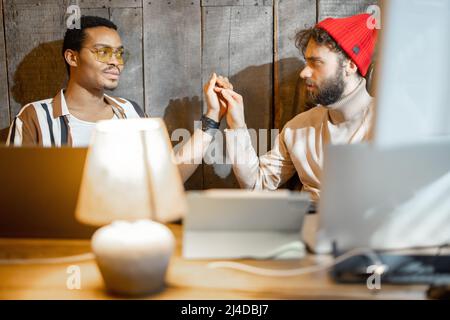 Gay couple working on computers at home office Stock Photo