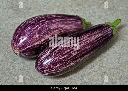 Striped eggplants on granite background Stock Photo