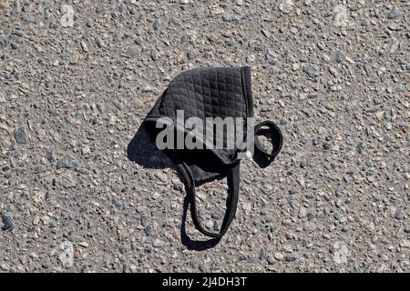 Face mask on floor in street. Improperly discarding used face mask. Stock Photo
