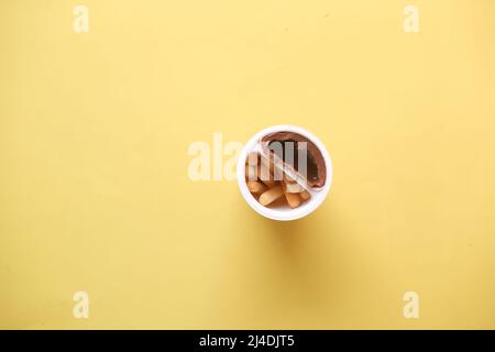 breadstick with chocolate spread cream in a container on yellow background  Stock Photo