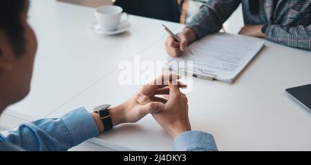 Employer or recruiter reading a resume during about colloquy his profile of candidate, employer conducting a job interview, manager resource Stock Photo