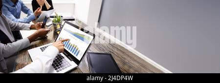 Side View Of Businesspeople Examining Graph On Computer At Workplace Stock Photo