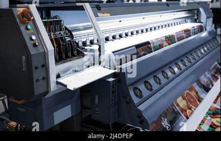 Wide format inkjet printer working on glossy poster. Advertising industry. Stock Photo
