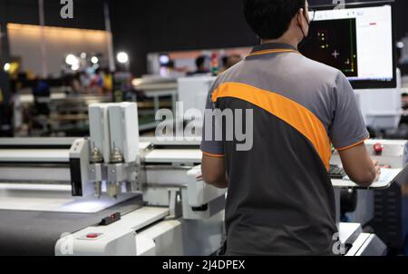 Industrial technician operating CNC laser cutting machine. Industrial manufacture. Stock Photo