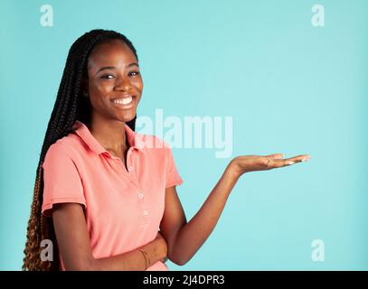 African American woman with upturned palm. Spokesperson pose holding your product in the palm of her hand. Stock Photo