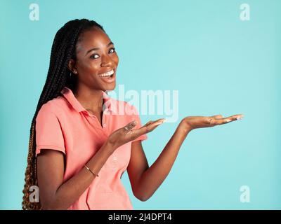 African American woman with upturned palm. Spokesperson pose holding your product in the palm of her hand. Stock Photo