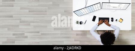 Looking At Invoice And Spreadsheet On Computer At Work Stock Photo