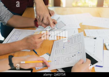 UX or UI designers discussing and designing on digital tablet and smartphone application layout prototype project. Stock Photo