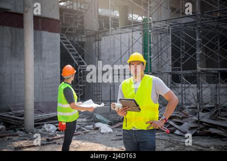 Architect, Engineer, Contractor, or Construction manager holding digital tablet standing at a construction site. Stock Photo
