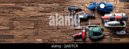 Various Power Tools Laying On Wooden Desk Stock Photo