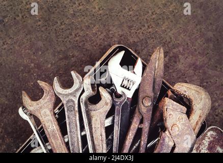 Toolbox with old vintage garage tools on rust metal background. Top view with copy space Stock Photo